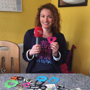 Sonja Spörlein con un micrófono de Radio EINS y pegatinas de Zuckerschmuck sobre la mesa